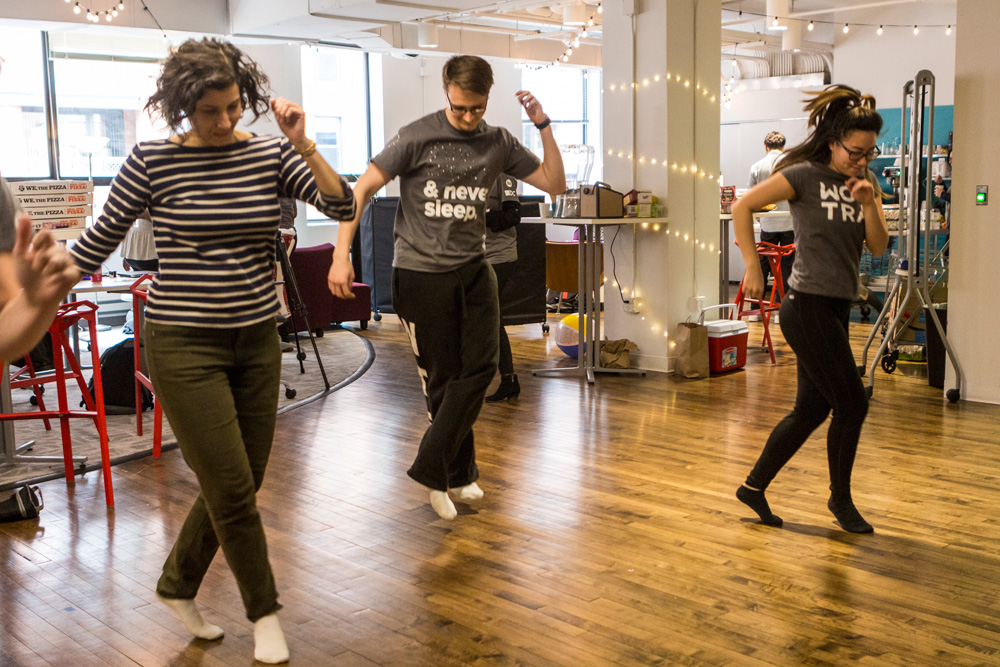 Participants are dancing in their socks during a work break.