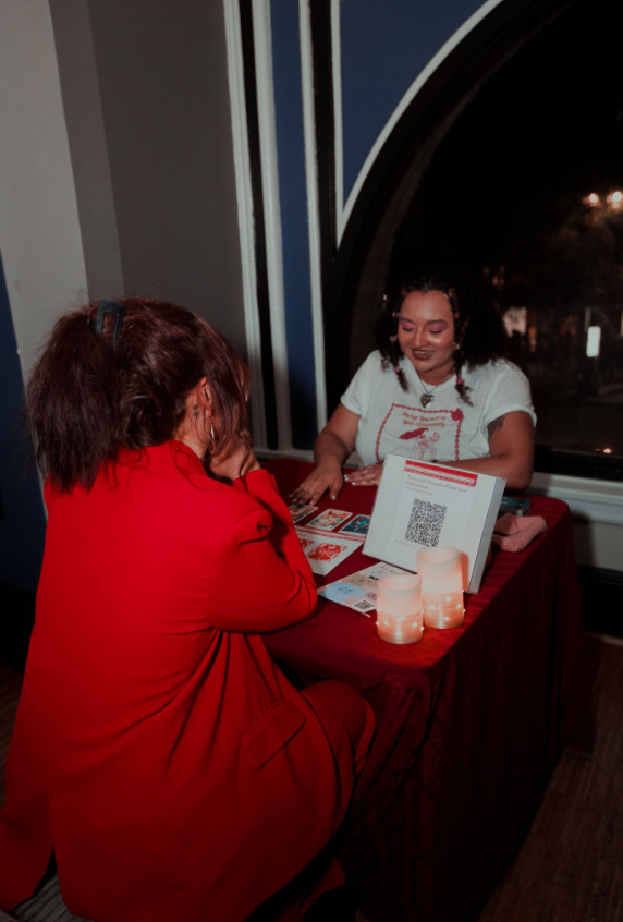 photo of Logan doing crowdfunding tarot readings for AlphabetSoup’s Scissor Inn party